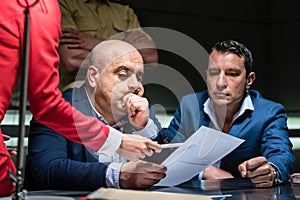 Middle-aged man calling his attorney during a difficult police interrogation photo