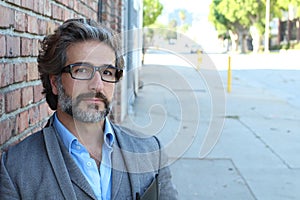 Portrait of middle aged modern business man with salt and pepper and glasses alone with copy space