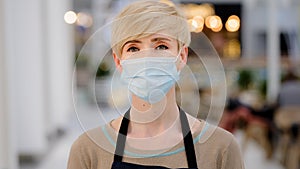 Portrait middle-aged woman adult lady cafe worker 40s female coffee shop owner waitress in protective medical face mask