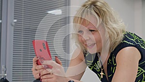 Portrait of middle aged woman is browsing phone training on exercise bike.