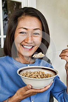 Portrait of middle aged woman Eating Breakfast Cereal