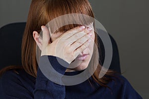 Portrait of middle aged woman holding hand on eyes