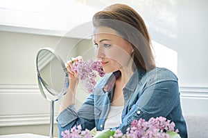 Portrait of middle-aged woman with make-up mirror