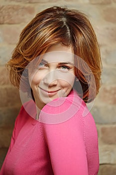 Portrait of middle aged woman with short red hair at home