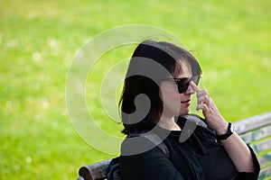 Portrait of a middle-aged woman sitting on a bench in the park