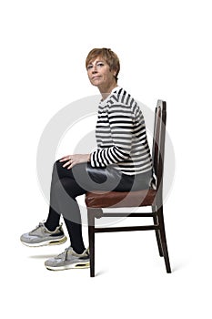 portrait of a middle aged woman sitting an chair on white