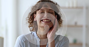 Portrait middle-aged woman standing indoor laughs over joke