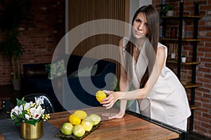 Portrait middle-aged woman standing at table with fruits in business suit