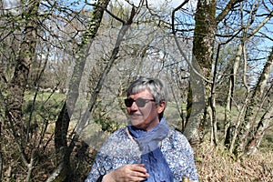 Portrait of a middle-aged woman through the walk in nature in a good mood