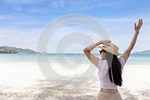 Portrait  middle shot view of woman stand in white T shirt and hat looking out towards blue ocean and sky, Women enjoy with