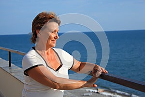 Portrait of middleaged woman on balcony over sea