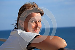 Portrait of middleaged woman on balcony over sea photo