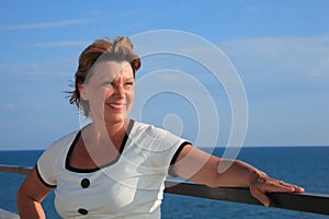 Portrait of middleaged woman on balcony over sea