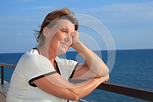 Portrait of middleaged woman on balcony over sea