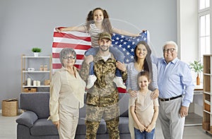 Portrait of a military father and his big happy family with an American flag in his hands.