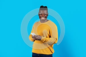 Portrait Of Millennial Black Man Holding Mobile Phone And Looking At Camera