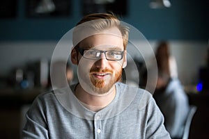 Portrait of millennial man posing sitting in cafe