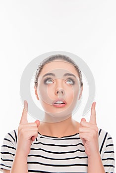 Portrait of minded girl pointing up with open mouth