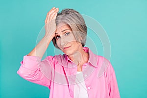 Portrait of minded grandmother in pink stylish shirt touch forehead lost all money bankrupt and loser  on cyan