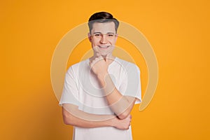 Portrait of minded happy young man dreaming isolated over yellow background