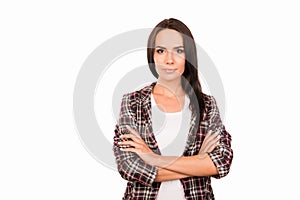 Portrait of minded young woman in checkered shirt with crossed hands