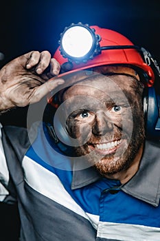 Portrait miner coal man in helmet with lantern in underground mine. Concept industrial engineer