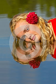 Portrait mirror image blonde woman in water