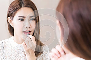 Portrait in mirror of smiling caucasian young woman model with glamour red lips and bright makeup.