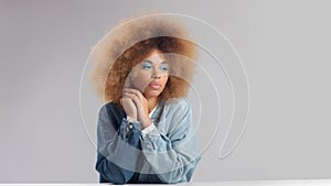 Portrait of mixed race black woman with afro hair wears a denim oversize shirt