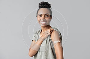 Portrait of a mixed race female girl with plaster on her arm after getting a vaccine.