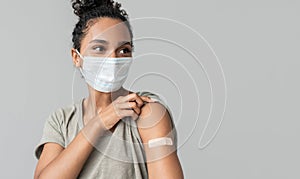 Portrait of a mixed race female girl wearing corona face mask after getting a vaccine.