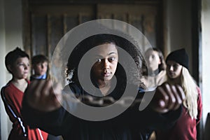 Portrait of mixed-race teenager girl with hands in chains indoors in abandoned building.