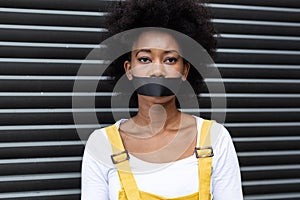 Portrait of mixed race woman having black tape on mouth