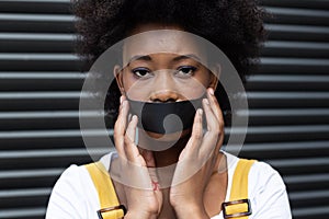 Portrait of mixed race woman having black tape on mouth