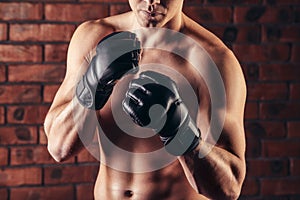 Portrait of mma fighter in boxing pose against brick wall