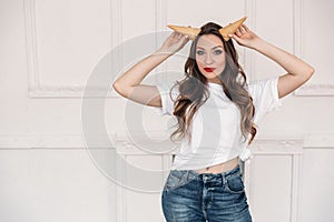 Portrait of a model holding in her hand a wafer cup for an ice cream with emotions. a girl in a white T-shirt with curly