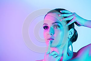 Portrait of model posing in studio with color neon lights