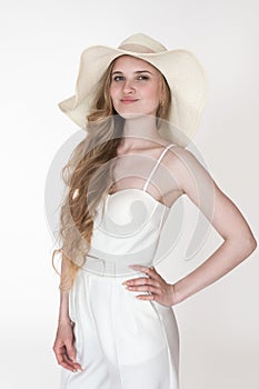 Portrait of model wearing her new clothes, to dress up straw hat, white cupped corset top, trousers