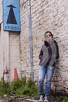 Portrait of a model wearing sunglasses, scarf, skinny trousers