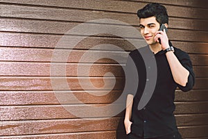 Portrait model young handsome male suspect Turkish middle eastern brunette in black shirt uses hand phone to call