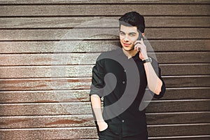 Portrait model young handsome male suspect Turkish middle eastern brunette in black shirt uses hand phone to call