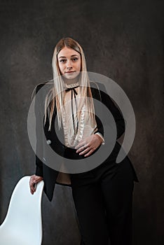 Portrait of a modern stylish caucasian woman wear classik black suit isolated on black