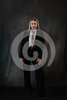 Portrait of a modern stylish caucasian woman wear classik black suit isolated on black