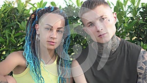 Portrait of modern young couple of man and woman with tattoos and trendy hairstyles