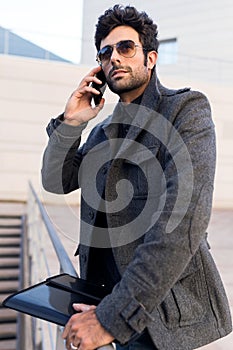 Modern young man using his mobile phone in the street.