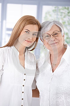 Portrait of mother and adult daughter smiling