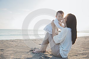 Portrait of mother and baby in the beach at sunset