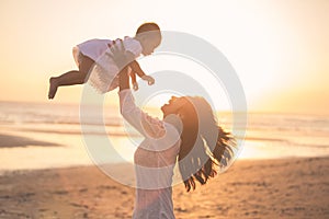 Portrait of mother and baby in the beach at sunset