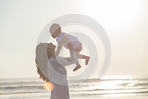 Portrait of mother and baby in the beach at sunset