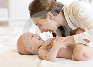 Portrait of mother and baby laughing and playing
